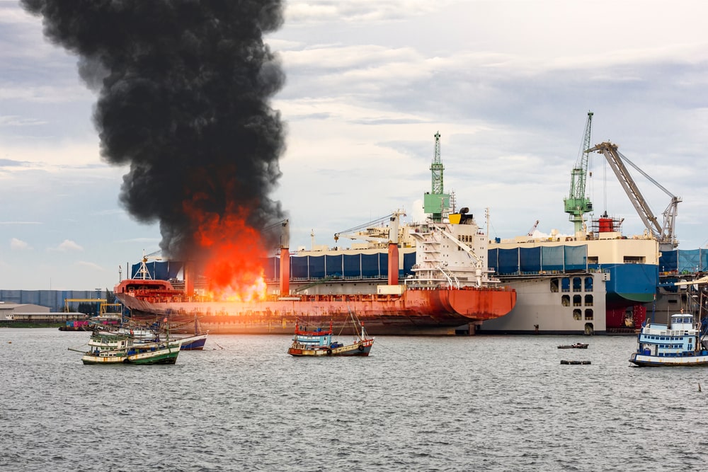A Large Ship In Flames In A Port