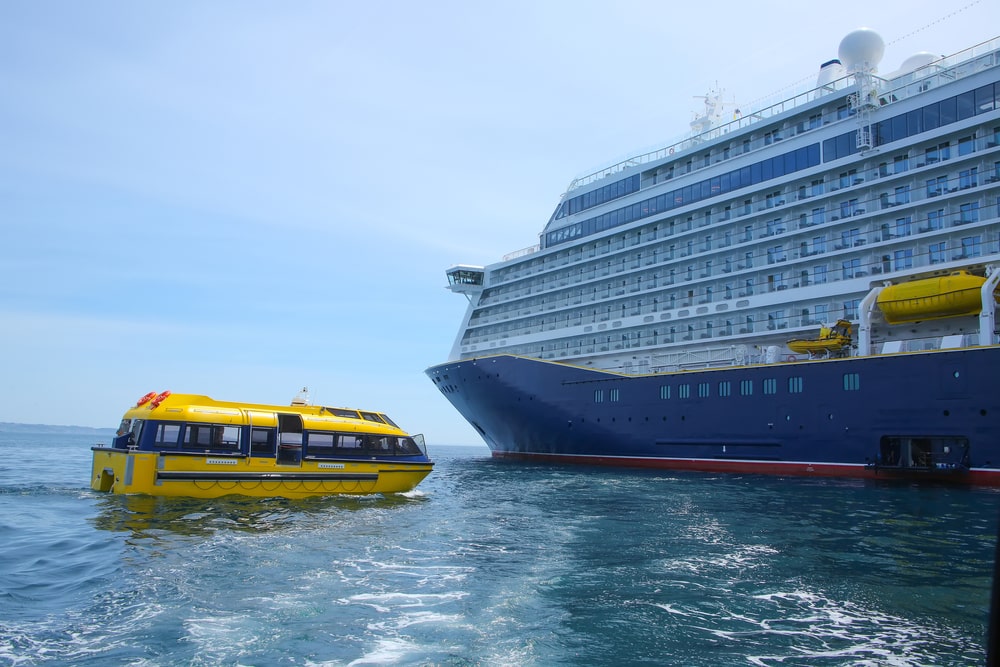 Yellow Tender Boat Carrying Passengers To A Cruise Ship